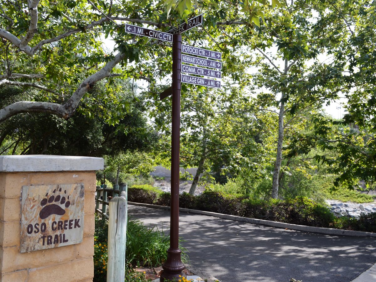 Entrance sign and paved path at the Oso Creek Trail in Mission Viejo